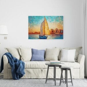 Beautiful canvas Sailboat on the water in front of an orange and blue sky with clouds
